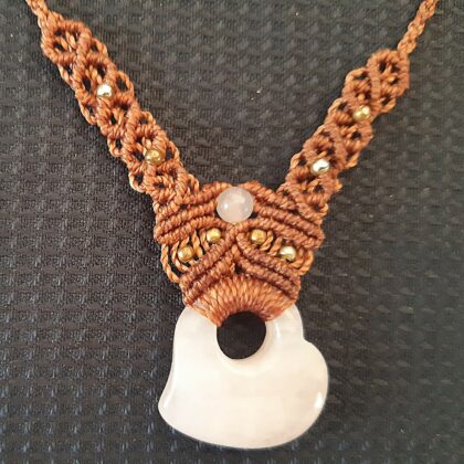 collier marron contenant un coeur quartz rose